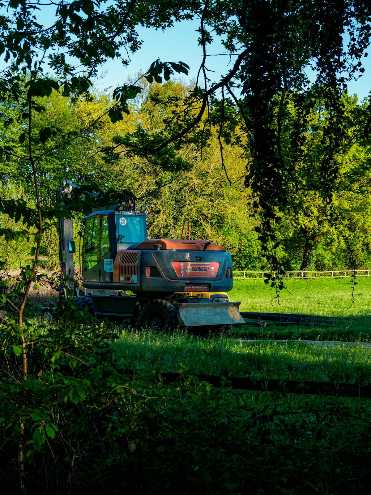 Excavator parked in a grassy equipment yard