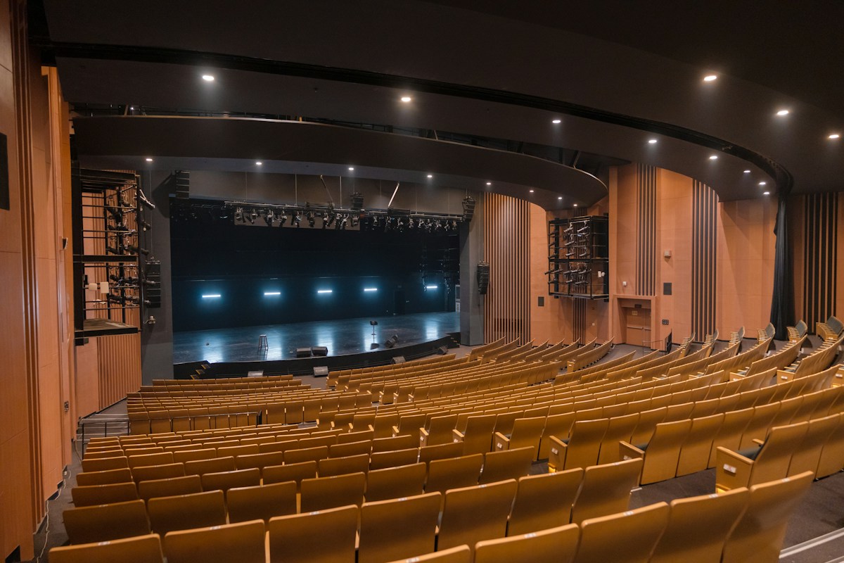 Empty theater with rows of seats and a lit stage