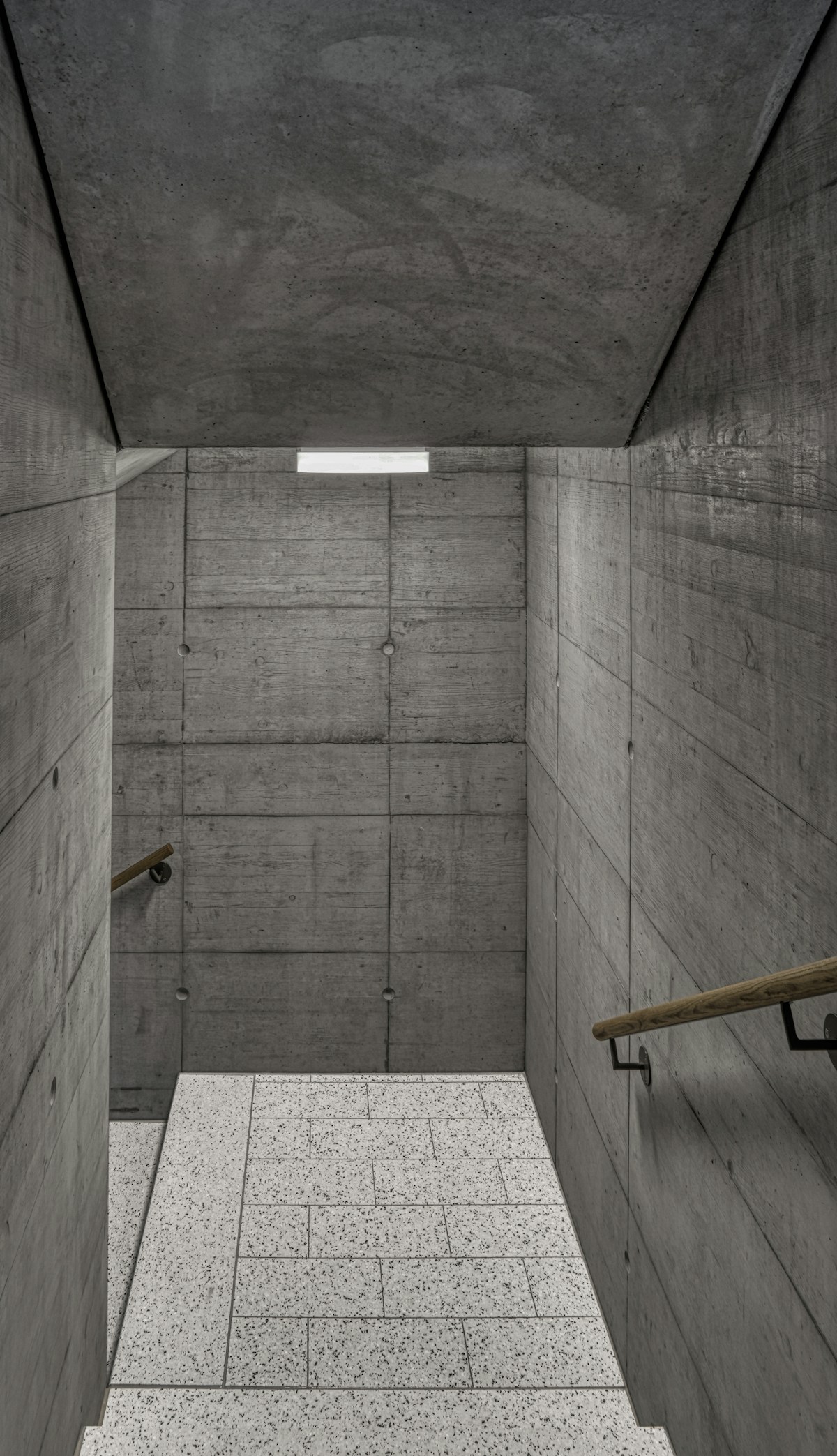 an empty room with concrete walls and stairs